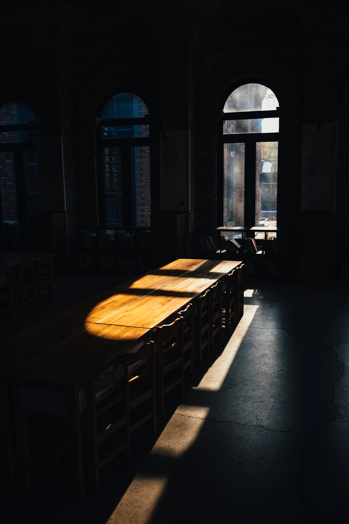 A long empty wooden table in sunlight