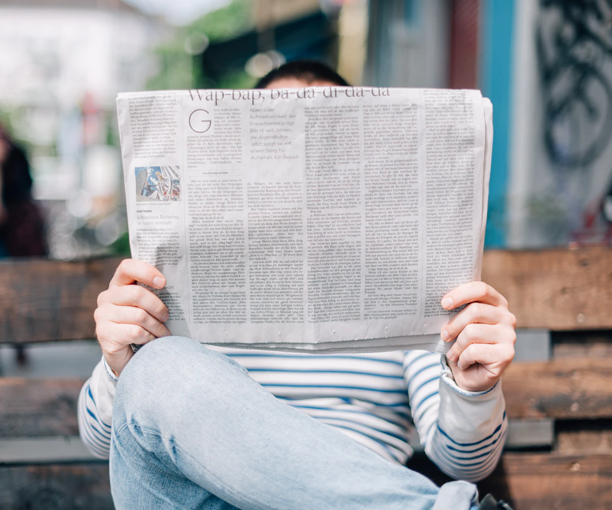 A man on a bench reading a newspaper